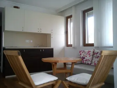 a kitchen with a table and two chairs and a couch at Complex Kentavar - Free Fast WiFi in Sveti Vlas