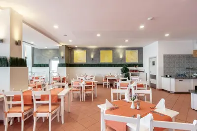 a restaurant with tables and chairs and a kitchen at AluaSun Helios Beach - All Inclusive in Obzor