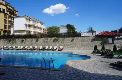 a swimming pool with lounge chairs next to a building at Dom-El Real Apartments Amphora in Sveti Vlas