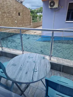 a table and chairs on a balcony with a pool at Dara Hotel in Primorsko