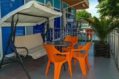 a table and chairs and an umbrella on a balcony at Dara Hotel in Primorsko