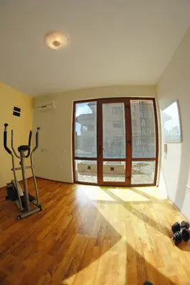 an empty room with a gym with a large window at Oasis Beach Apartments Kamchia in Kamchia