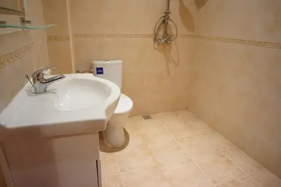 a bathroom with a sink and a toilet at Oasis Beach Apartments Kamchia in Kamchia