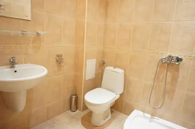a bathroom with a toilet and a sink and a shower at Oasis Beach Apartments Kamchia in Kamchia