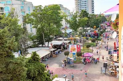 a crowd of people walking around a market in a city at Menada Midia Apartments in Sunny Beach