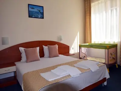 a bedroom with a bed with towels on it at Family Hotel Diana in Pomorie