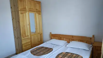 a bedroom with a bed and a wooden cabinet at Complex Argo in Ravda
