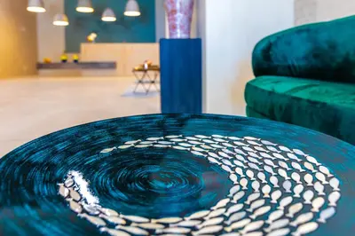 a blue circular table in a room with a couch at Marina Burgas Hotel in Burgas City