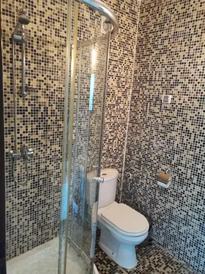 a bathroom with a toilet and a glass shower at Clara Sea View in Burgas City