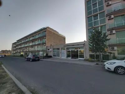 two cars parked in a parking lot next to a building at Clara Sea View in Burgas City