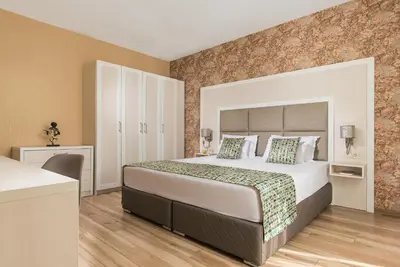 a hotel room with a large bed and a desk at Marina White Sands Beach Hotel-All Inclusive in Obzor