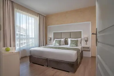 a bedroom with a large bed and a large window at Marina White Sands Beach Hotel-All Inclusive in Obzor