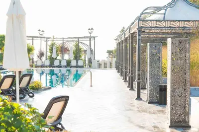 a swimming pool with chairs and an umbrella at Marina White Sands Beach Hotel-All Inclusive in Obzor