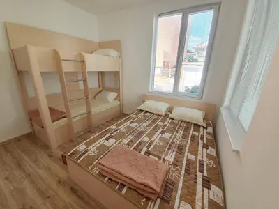 a bedroom with a bed and bunk beds at Апартамент Катлена in Pomorie