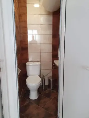 a small bathroom with a toilet and a sink at Апартамент Катлена in Pomorie
