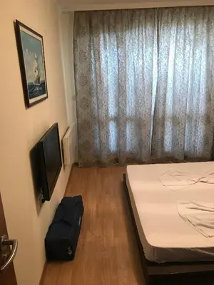 a small room with a bed and a television at Black Sea Apartment in Nesebar