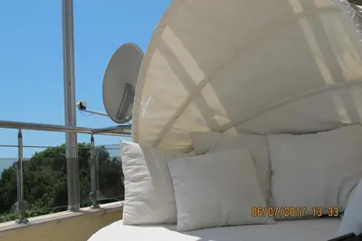 a bed with white pillows on a balcony at Black Sea Apartment in Nesebar