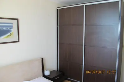 a large wooden closet in a bedroom with a bed at Black Sea Apartment in Nesebar