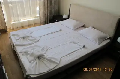 a bed with white sheets and pillows on it at Black Sea Apartment in Nesebar