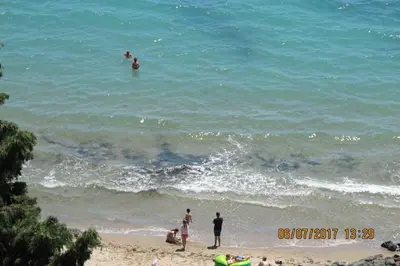 a group of people standing in the water at the beach at Black Sea Apartment in Nesebar