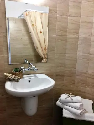 a bathroom with a sink and a mirror and towels at Alba Family Club Hotel in Primorsko