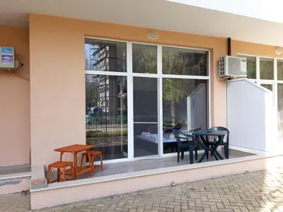 a patio with chairs and a table in front of a window at studio Grand Kamelia in Sunny Beach