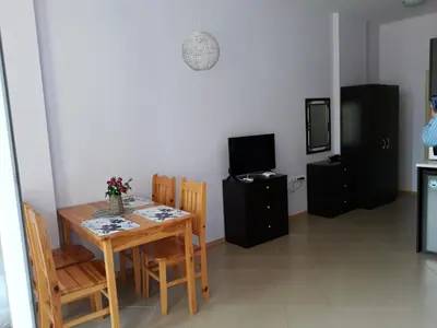 a dining room with a table and chairs and a television at studio Grand Kamelia in Sunny Beach