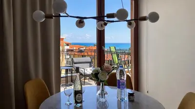 a table with a view of the ocean from a balcony at GARDEN OF EDEN Modern Apartments - APARTELLO,com in Sveti Vlas