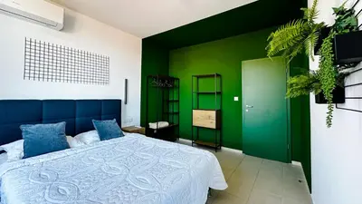 a bedroom with a bed with a green wall at GARDEN OF EDEN Modern Apartments - APARTELLO,com in Sveti Vlas