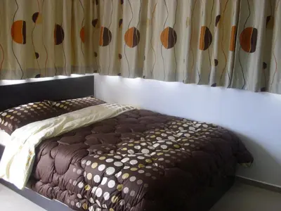 a bed sitting in a room with a curtain at Apartament Villa Del Mare in Primorsko
