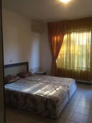 a bedroom with a large bed and a window at Apartment on the sea at St Nikolas Complex-Irina in Chernomorets