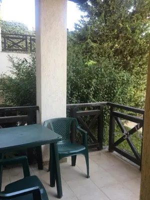 a patio with two tables and chairs and a fence at Apartment on the sea at St Nikolas Complex-Irina in Chernomorets