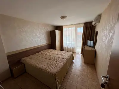 a bedroom with a bed in a room with a window at Stamatovi Family Hotel in Pomorie