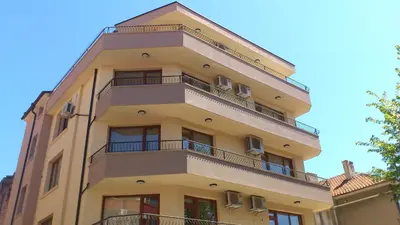 a tall yellow building with balconies on it at Stamatovi Family Hotel in Pomorie