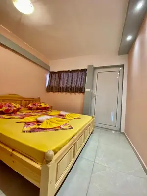 a bedroom with a large bed with yellow sheets at Fener Guest House in Pomorie