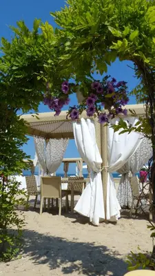 a table and chairs under an umbrella on the beach at Oasis Beach Studios in Sunny Beach