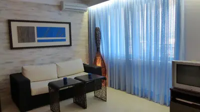 a living room with a couch and a television at Oasis Beach Studios in Sunny Beach