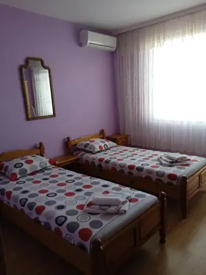 two twin beds in a room with a window at Къща за гости Ганчеви in Sozopol
