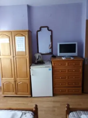 a room with a refrigerator and a tv and a mirror at Къща за гости Ганчеви in Sozopol