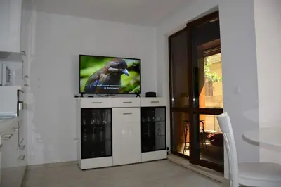 a tv sitting on top of a white entertainment center at Unbeatable Location - New Lux Apartment Varna beach by Flat Mаnager in Varna City