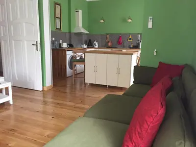 a living room with a couch and a kitchen at Апартамент ELSOR in Burgas City