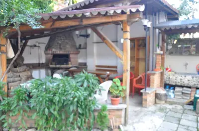 a pavilion with a fireplace in a yard with plants at Апартамент ELSOR in Burgas City