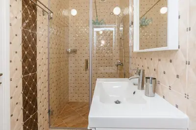 a bathroom with a sink and a shower at Апартамент ELSOR in Burgas City