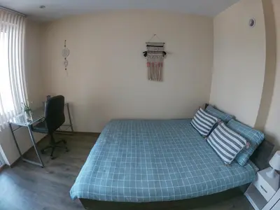 a bedroom with a blue bed with a chair and a window at By the CATHEDRAL · TOP center · 2 Bedroom FLAT in Varna City