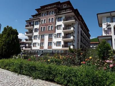 a tall white building with flowers in front of it at FREGATA 15 Studio Sveti Vlas in Sveti Vlas