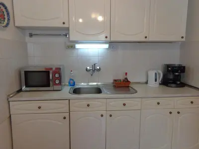 a kitchen counter with a sink and a microwave at Zoya Apartment in Burgas City