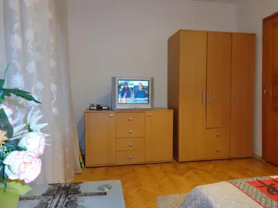 a living room with a television on a dresser at Zoya Apartment in Burgas City