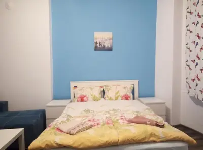 a bedroom with a bed with a blue wall at Casablanca City in Varna City