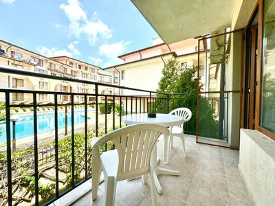 a balcony with a table and chairs and a pool at Arkite Complex in Sunny Beach