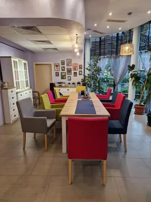 a room with colorful chairs and a table in a room at Pool View Studio, Pollo Resort, Sunny Beach in Sunny Beach